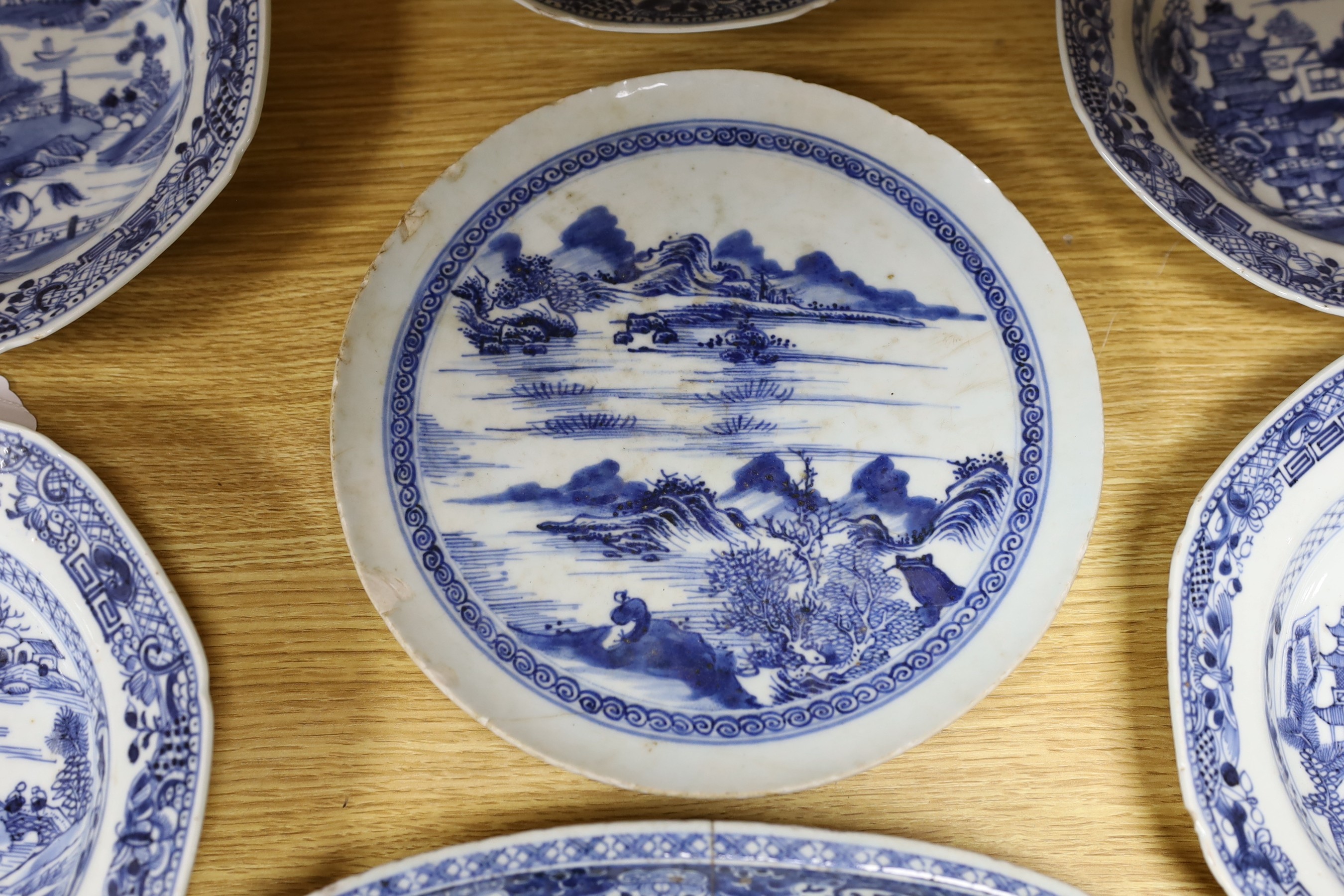 A selection of severn 18th century Chinese export blue and white dishes, largest 35cm wide
